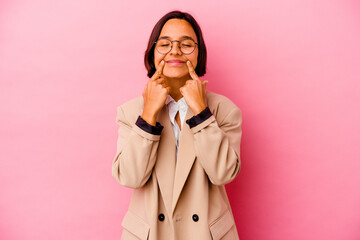 Young business mixed race woman isolated on pink background doubting between two options.