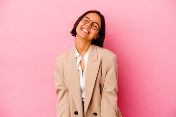 Young business mixed race woman isolated on pink background laughs and closes eyes, feels relaxed and happy.