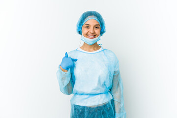 Young surgeon latin woman isolated on white background person pointing by hand to a shirt copy space, proud and confident