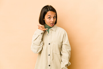 Young hispanic woman isolated showing a mobile phone call gesture with fingers.