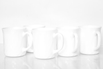 Group of white tea cup with reflection in glass surface on white background