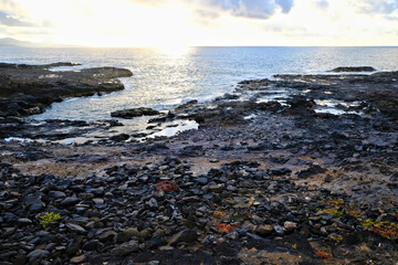 Sea view with sunset glow, Gran Canaria rocky volcanic shores.