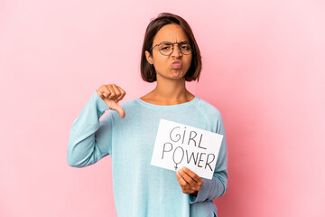 Young hispanic mixed race woman holding a girl power message placard showing a dislike gesture, thumbs down. Disagreement concept.