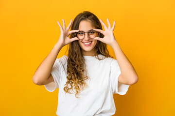 Young caucasian woman showing okay sign over eyes