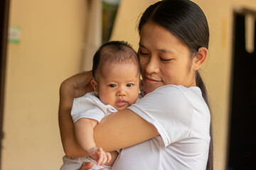 Young Asian mother holding little daughter in the park, Mother play enjoying with her cute baby girl in outdoor, copy space