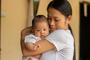 Young Asian mother holding little daughter in the park, Mother play enjoying with her cute baby girl in outdoor, copy space