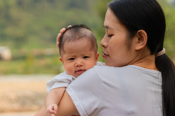 Young Asian mother holding little daughter in the park, Mother play enjoying with her cute baby girl  outdoor, copy space
