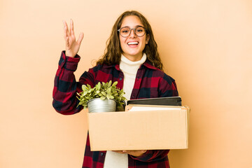 Young caucasian woman moving holding a box isolated receiving a pleasant surprise, excited and...