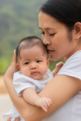 Young Asian mother holding little daughter in the park, Mother play enjoying with her cute baby girl  outdoor, copy space
