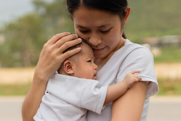 Fototapeta premium Young Asian mother holding little daughter in the park, Mother play enjoying with her cute baby girl outdoor, copy space 
