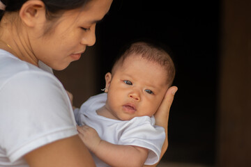 Young Asian mother holding little daughter in the park, Mother play enjoying with her cute baby girl in outdoor, copy space