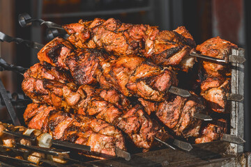 Fried kebab meat on skewers in a street establishment, close-up