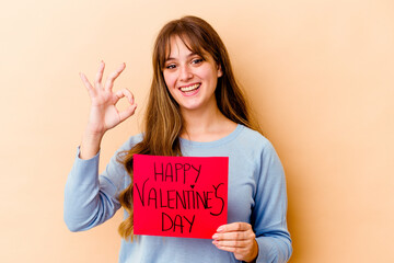 Fototapeta na wymiar Young caucasian woman holding a Happy Valentines day isolated cheerful and confident showing ok gesture.