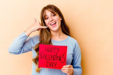 Fototapeta na wymiar Young caucasian woman holding a Happy Valentines day isolated showing a mobile phone call gesture with fingers.