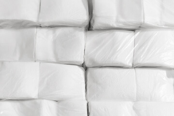 Pile of white wrapped paper napkins in warehouse background