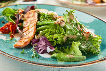 Seafood salad  with crispy buckwheat and mixed greens. Frutti di Mare salad with mixed seafood - salmon, calamari, octopus. Gourmet restaurant salad plate.
