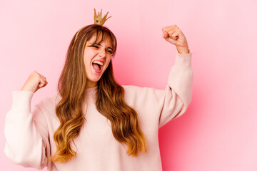 Young caucasian woman with princess crown isolated raising fist after a victory, winner concept.