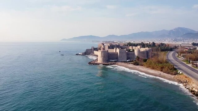Mamure Castle or Mamure kalesi is a medieval castle in the Anamur district of Mersin Province, Turkey. Aerial view of castle, sea, mountains and numerous greenhouses