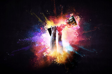 Fototapeta na wymiar Hands holding champion cup on colourful splashes background. Mixed media