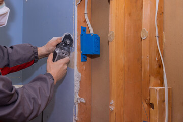 Repair of home on angle hand electric power tools on cutting gypsum drywall sheet with damaged...