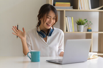 Female worker say hi to her  coworkers while video conference, work from home concept © bongkarn