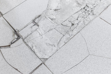 Old gray broken tile floor construction repair background, renovation concept