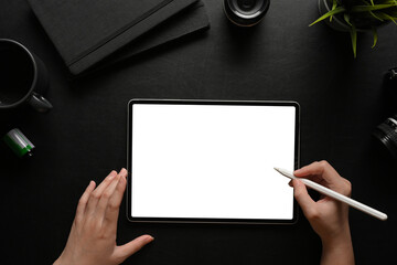 Top view of female hands using digital tablet with stylus pen on dark workspace © bongkarn
