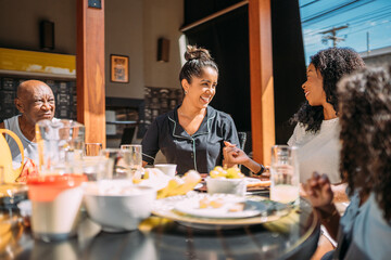 Happy Latinx family having breakfast at home.