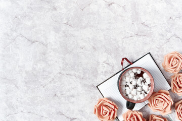Planning concept. Flower composition. An open empty diary, a cup of cocoa with marshmallows and roses are on a gray background. Flat lay, copy space.