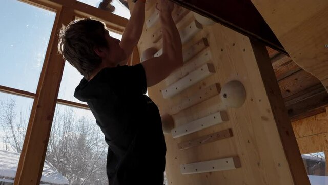 Climber training on the Campusboard in Winter in Homegym