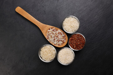 Long grain basmati medium grain jasmine short grain pilaf polau risotto brown low glycaemic index gi rice in small glass bowl wooden spoon on black background copy text space top flat lay view