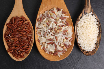 Long grain basmati medium grain jasmine short grain pilaf polau risotto brown low glycaemic index gi rice in wooden spoon on black background copy text space top flat lay view