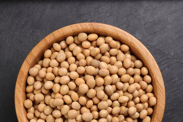 Soyabeans soya beans in wooden bowl over black background copy text space flat lay top view
