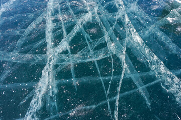 cracks on clear thick frozen Baikal lake in winter season with sunny blue sky