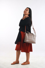 Young woman in casual outfit with stylish bag on white background.