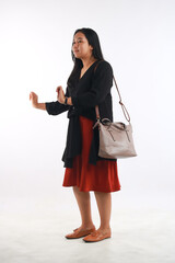 Young woman in casual outfit with stylish bag on white background.