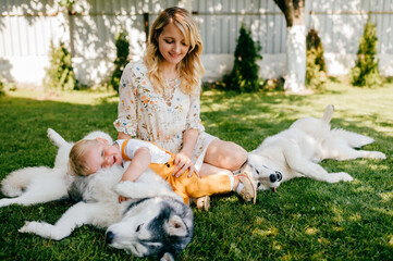 Mother and son posing with two dogs on the grass