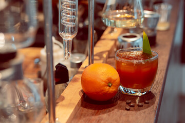 Close-up coffee mixed with orange juice in a clear glass Placed next to a large orange in the laboratory