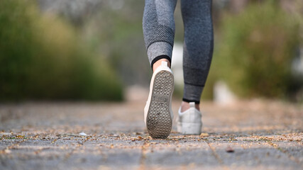 Close up of legs of sportswoman running on the road outside. Healthy Lifestyle.