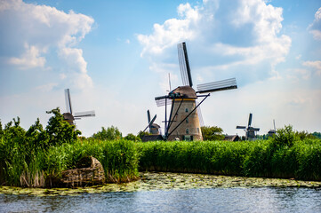 Scenic rural view with canals and traditional Dutch windmills at Kinderdijk, the Netherlands, on a summer day - 422223294