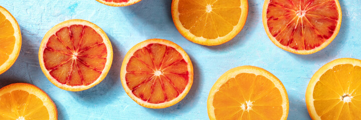 Summer panorama with fresh ripe oranges on a blue background