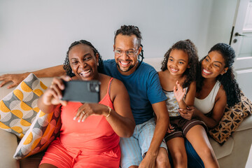 Happy Latinx family making a video call on their cell phone