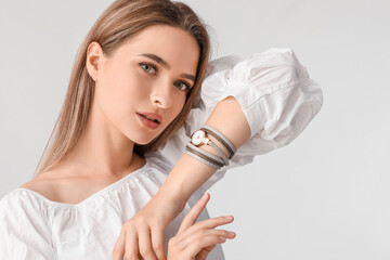 Woman with stylish wrist watch on white background