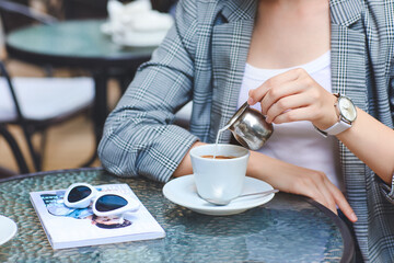 Fototapeta na wymiar Woman with stylish wrist watch drinking coffee in cafe