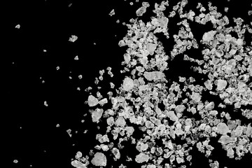 Pieces of  white sea salt on a black background. clear crystalline pebbles. white ice cubes