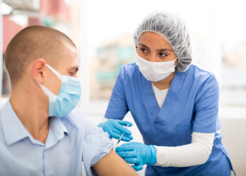 Female Doctor Ready To Make Injection To Male Visitor In Hospital