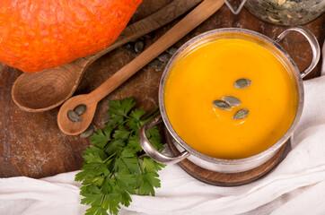 Bowl of pumpkin soup on rustic wooden background