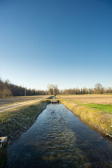 Fototapeta na wymiar irrigation channel in the lowland countryside in northern Italy