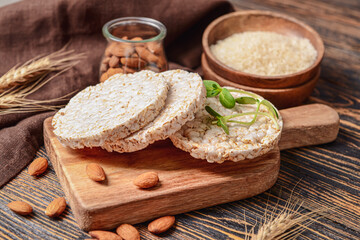 Fototapeta na wymiar Board with rice crackers on wooden background
