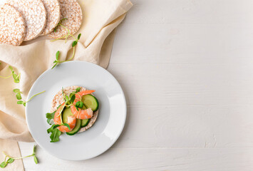 Rice cracker with cucumber and shrimp on white wooden background